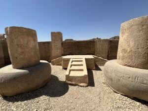 Large stone column bases and carved architectural blocks at Medinet Habu in Luxor