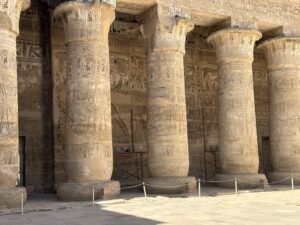 Rows of ancient Egyptian papyrus-form columns covered with hieroglyphs and reliefs at Medinet Habu