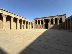 Open stone courtyard lined with carved columns at the Temple of Horus in Edfu, Egypt