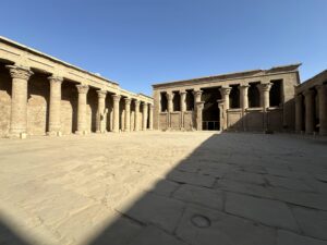 Open stone courtyard lined with carved columns at the Temple of Horus in Edfu, Egypt