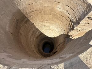 Deep circular stone nilometer shaft at the Temple of Kom Ombo beside the Nile River in Egypt