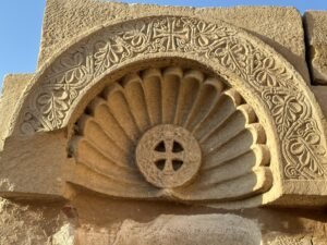 Carved stone shell niche with a central cross and floral ornament from a Coptic Christian site in Egypt