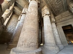 Massive hieroglyph-covered columns with Hathor-face capitals inside Dendera Temple in Egypt