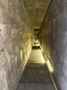 Steep narrow stairway lined with carved hieroglyphic walls inside the Temple of Hathor at Dendera, Egypt