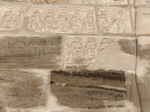 Rows of carved royal cartouches and hieroglyphs on a sandstone wall at Karnak Temple