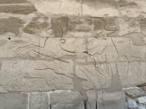 Ancient Egyptian relief of a pharaoh and deity carved on a sandstone wall at Karnak Temple