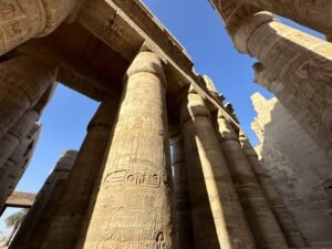 Towering carved sandstone columns and lintels viewed from below at Karnak Temple in Luxor
