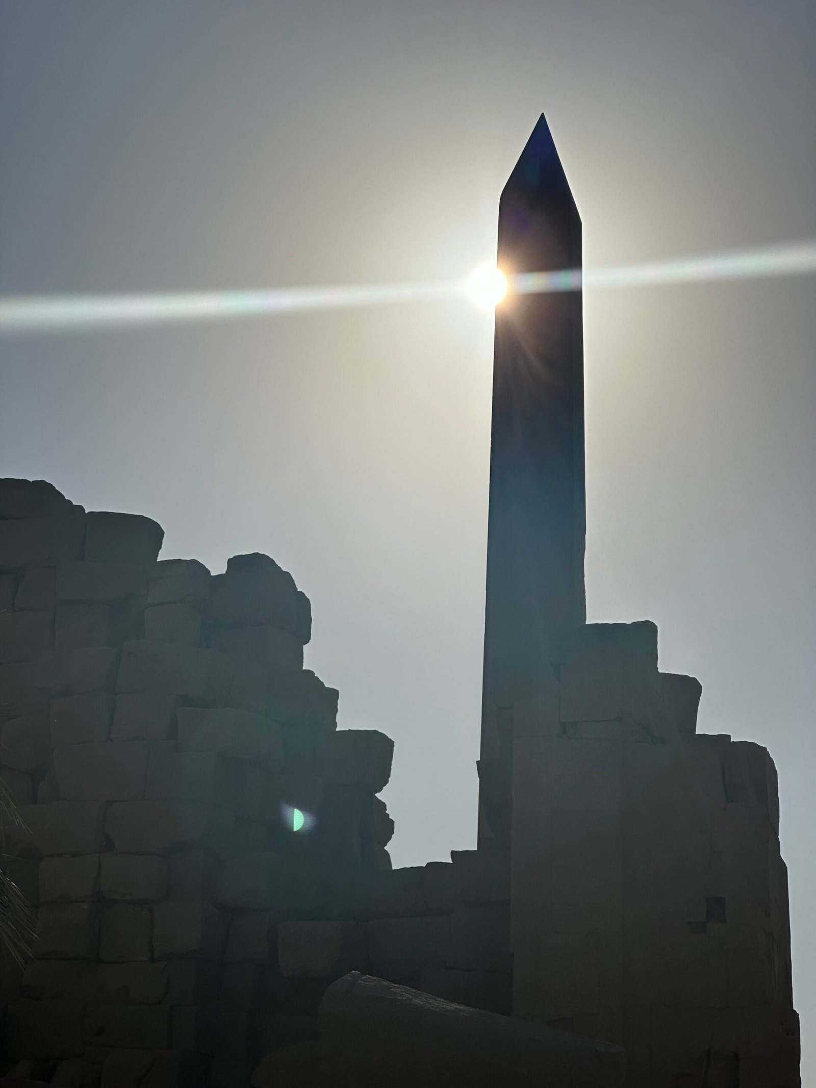 Obelisk of Thutmose I at Karnak Temple silhouetted against the bright sun in Luxor, Egypt