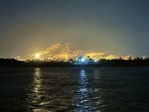 Theban hills on Luxor’s West Bank illuminated at night across the dark Nile River