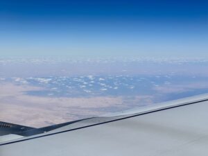 Aerial view from an airplane over the Faiyum Oasis depression in Egypt, with desert terrain and scattered clouds