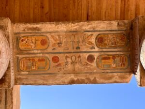 Painted hieroglyphs and royal cartouches preserved on a stone lintel at Karnak Temple in Luxor