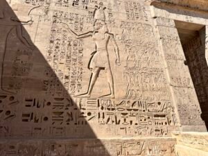 Large Ptolemaic king relief surrounded by processional figures and hieroglyphic inscriptions at the Temple of Horus at Edfu in Upper Egypt