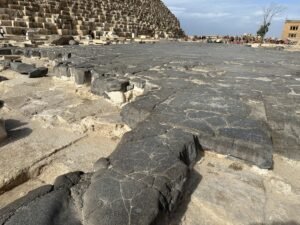 Dark basalt paving beside the lower limestone courses of the Great Pyramid of Khufu on the Giza Plateau