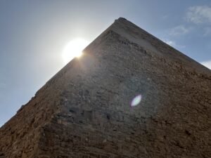 Pyramid of Khafre on the Giza Plateau viewed from below with sunlight shining around its upper casing stones