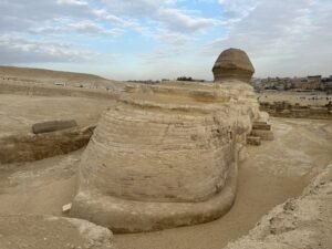 Rear and side view of the Great Sphinx showing its long limestone body and head on the Giza Plateau