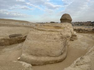 Rear and side view of the Great Sphinx showing its long limestone body and head on the Giza Plateau