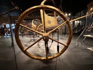 Large gilded wheel and decorated body of Tutankhamun's ceremonial state chariot, JE 61990A, from tomb KV62 and displayed at the Grand Egyptian Museum in Giza