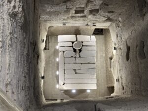 View down into the inner burial chamber of the Step Pyramid of Djoser at Saqqara, showing the stone sarcophagus chamber below