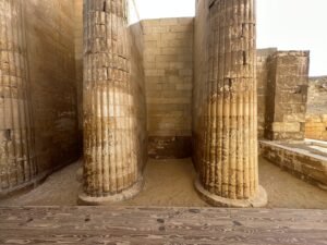 Tall fluted limestone columns in the entrance colonnade of Djoser’s Step Pyramid complex at Saqqara