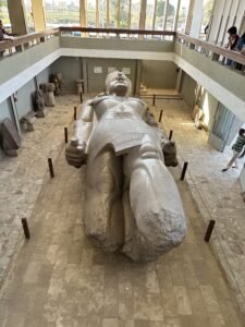 Massive fallen limestone statue of Pharaoh Ramesses II displayed in the Memphis open-air museum