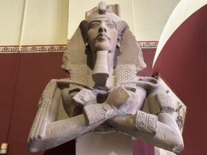Sandstone colossus of Pharaoh Akhenaten in the khat and double crown from Karnak Temple, displayed in the Egyptian Museum in Cairo