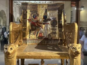 Golden throne of Tutankhamun, JE 62028, showing Queen Ankhesenamun anointing the king beneath the Aten sun disk, photographed in the Egyptian Museum in Cairo
