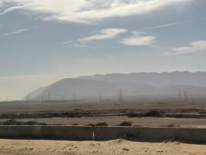 Jabal Attaka mountain range beyond the arid plain near the Gulf of Suez, Egypt, crossed by electrical transmission towers