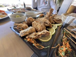 Large pieces of fried fish served on a black platter with lemon slices and shredded vegetables at an Egyptian restaurant