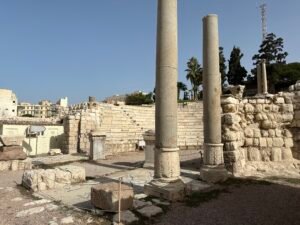 Two tall standing stone columns among excavated masonry and ruins at an Egyptian archaeological site