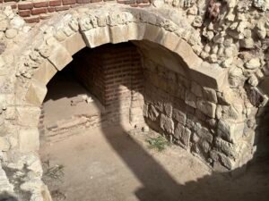 Low arched passage built from stone and brick within an excavated archaeological structure in Egypt