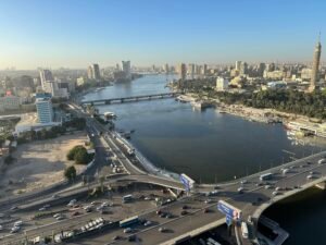 Elevated daytime view of Cairo with the Nile River, bridges, heavy traffic, and Cairo Tower