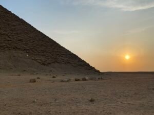 Lower slope of the Red Pyramid at Dahshur beside a low golden sun over the desert