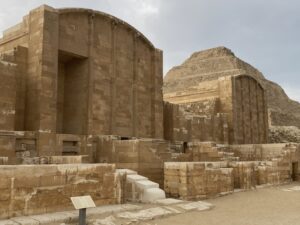 Reconstructed stone shrine facades in the Step Pyramid complex with Djoser’s pyramid rising behind