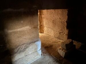 Sunlight entering through a small stone doorway within the archaeological site of Tanis in Egypt