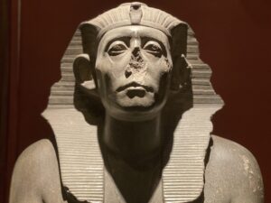 Black granite statue of 12th-Dynasty Pharaoh Senusret III, RT 18.4.22.4, wearing the pleated nemes headdress and uraeus, from the forecourt of Mentuhotep II’s temple at Deir el-Bahari, Egyptian Museum Cairo