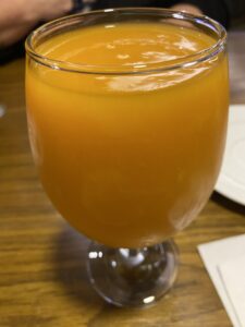 Glass of thick orange mango juice served at a restaurant table in Egypt
