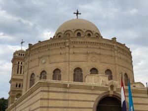 Historic domed church in Old Cairo with a cross above the roof and arched windows