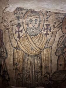 Detail of a 6th- to 7th-century Coptic wall painting of haloed desert saints with raised hands and crosses from St. Jeremiah Monastery at Saqqara, displayed at the Coptic Museum in Cairo