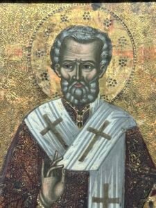 Painted Coptic icon of a haloed bishop saint wearing a cross-covered vestment