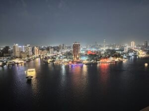 Night panorama of Cairo’s illuminated riverfront and boats on the Nile