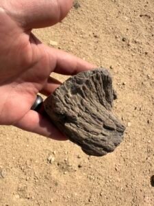 Weathered fibrous mudbrick fragment held in a hand at the Lahun archaeological site in Egypt