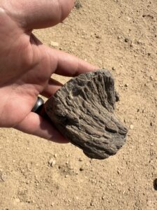 Weathered fibrous mudbrick fragment held in a hand at the Lahun archaeological site in Egypt