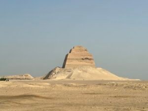 Meidum Pyramid rising above the flat desert landscape in Egypt beneath a clear sky