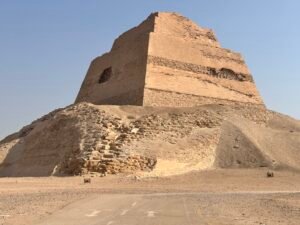 Collapsed outer layers and surviving stepped core of the Meidum Pyramid viewed from the desert in Egypt