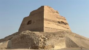 Meidum Pyramid showing its surviving stepped core above collapsed stone layers in the Egyptian desert