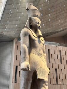 Colossal granite statue of Ramesses II, GEM 1, standing beneath the Grand Egyptian Museum roof in Giza, Egypt