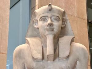 Upper body of the red-granite seated statue of King Amenhotep III, GEM 4607, displayed at the Grand Egyptian Museum in Giza