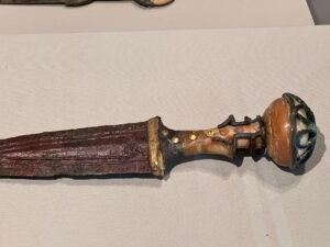 Close view of Queen Ahhotep’s ceremonial dagger, JE 4668 and CG 52660, showing its short grip, discoid pommel, silver and gold fittings, Grand Egyptian Museum