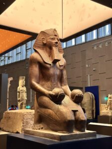 Colossal seated statue of Pharaoh Amenhotep II holding two rounded offering vessels, Dynasty 18, from Karnak and displayed at the Grand Egyptian Museum in Giza
