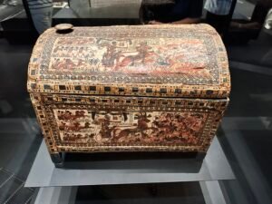 Tutankhamun’s painted wooden box, Carter 21 and JE 61467, from tomb KV62, with vivid chariot battle and lion-hunting scenes, displayed at the Grand Egyptian Museum in Giza
